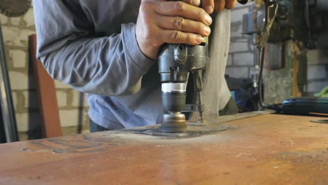 Hands of mechanic hold tool during operation. Worker polishes detail on table Stock-Footage 306125383