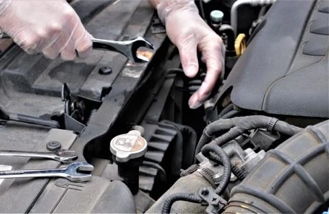 Hands of mechanic holding spanner fixing car engine Stock Photos