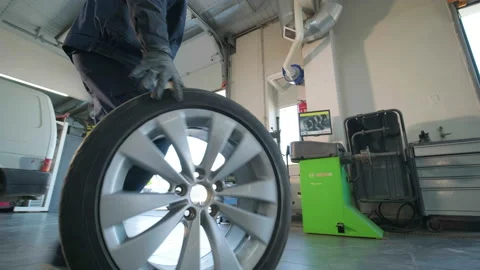 Hands of mechanic with tool, changing tyre of car at auto service Stock Footage 197037302
