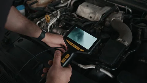 Hands of Mechanic Using Automotive Inspection Endoscope while Servicing Engine Stock Footage 329408704