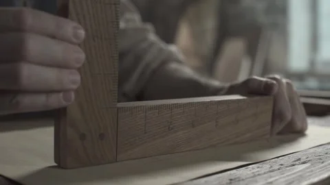 Hands of a medieval inventor checking a geometry drawing with a wooden ruler Stock Footage 337649667