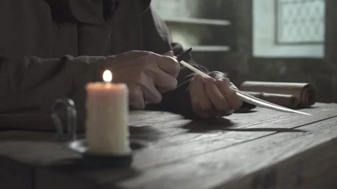 Hands of a medieval monk with a penknife making a scoop cut on a quill shaft 스톡 동영상 339231525