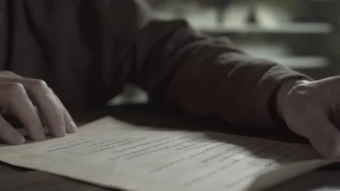 Hands of a medieval monk unrolling a parchment scroll outwards on a desk 動画素材 339631145