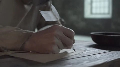 Hands of medieval prisoner writing first line with quill pen on parchment 스톡 동영상 340322914