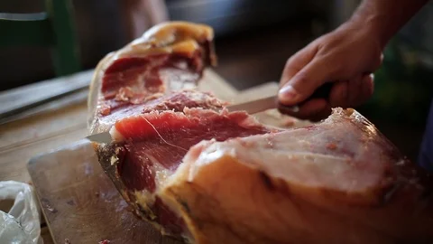 Hands of a men cut a slice of traditionally spanish jamon Video stock 85878431