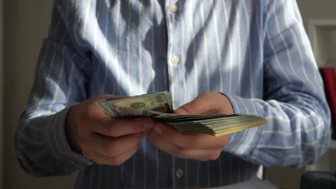 Hands meticulously count a thick pile of cash, emphasizing wealth, transactions Stock Footage 316751420