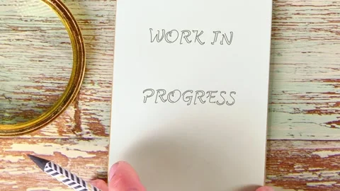 Hands meticulously form Work in Progress on paper, then a notepad Stock Footage 330789504