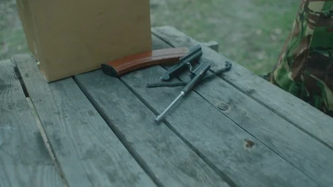 The hands of the militaries collect weapons on the table. Stock Footage 107794244