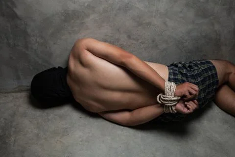 Hands of a missing kidnapped, abused, hostage, victim man tied up with rope Stock Photos