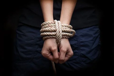 Hands of a missing kidnapped, abused, hostage, victim woman tied up with rope Stock Photos