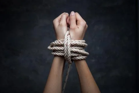 Hands of a missing kidnapped, abused, hostage, victim woman tied up with rope Stock Photos