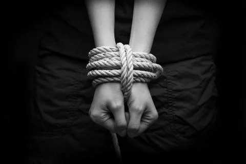 Hands of a missing kidnapped, abused, hostage, victim woman tied up with rope Stock Photos