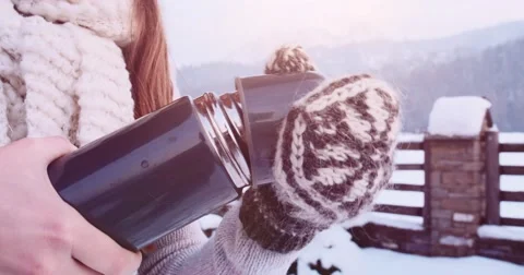 Hands in Mittens pouring Steaming Tea to Cup from Thermos, Winter. 4K SLOW-MO Видео 68826732