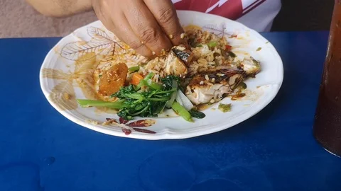 Hands mix rice with vegetable side dishes to eat. Stock Footage 126591537