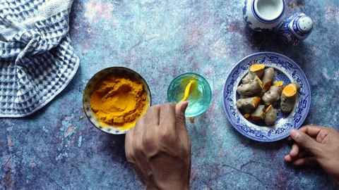 Hands mix turmeric with a water on a table. top view , Stock Footage 341908586