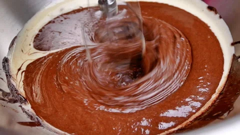 Hands mixing batter with melted chocolate by an electric mixer for makes brownie Stockbeeldmateriaal 158659978