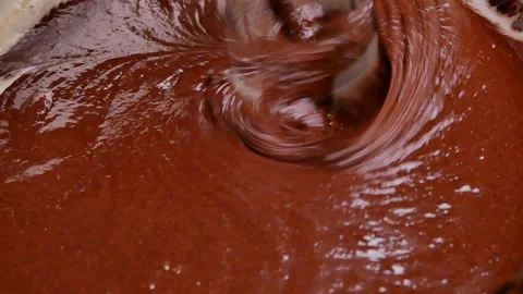 Hands mixing batter with melted chocolate by an electric mixer for makes brownie 動画素材 158660097