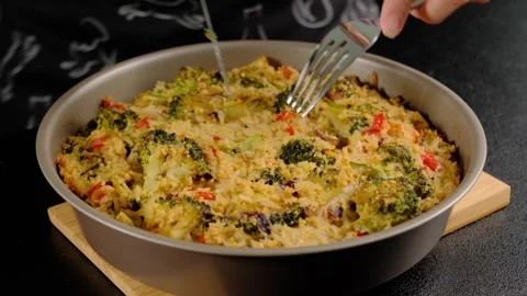 Hands Mixing Broccoli Casserole with Knife and Fork in Cooking Scene Vidéo 341444686