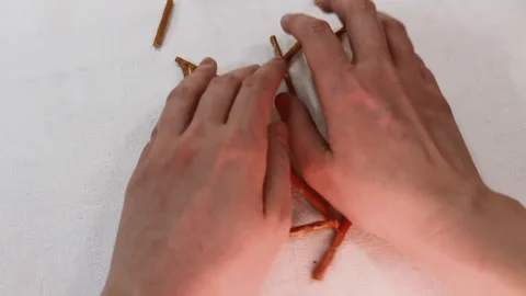 Hands mixing crispy salt straw sticks to make up word FOOD on white table. film Stock Footage 266434799