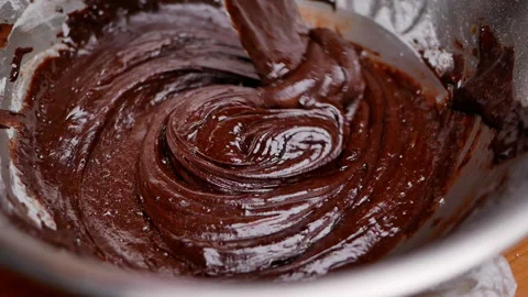 Hands mixing eggs, flour, melted chocolate and cocoa powder in bowl for brownies 動画素材 158661108