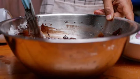 Hands mixing eggs, flour, melted chocolate and cocoa powder in bowl for brownies Stock Footage 158661120