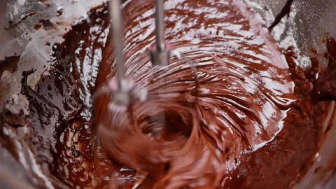 Hands mixing eggs, flour, melted chocolate and cocoa powder in bowl for brownies 動画素材 158661122