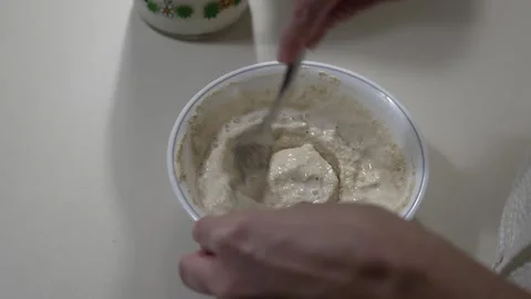 Hands mixing pancake batter with milk using a fork in white bowl 스톡 동영상 333155751