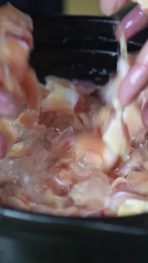 Hands mixing raw chicken pieces in a pot. Video stock 335711484