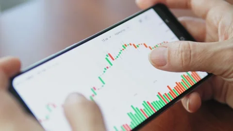 Hands with a mobile phone, checking stock market data. Scrolling through Video stock 218212684