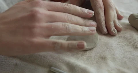 Hands mold soft clay, shaping a ceramic piece. The sculpting process highlights Stock Footage 301431195