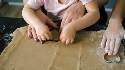 Hands of mom and kids shaping ginger cookie dough 動画素材 321953553