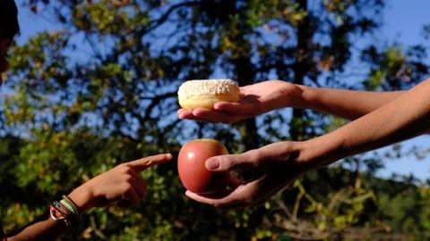 Hands of mother and son choosing between fruit and industrial pastries Stock Footage 222202311