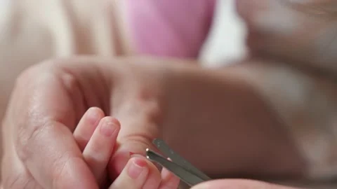 Hands of mother carefully cut tiny nails of baby girl Stock Footage 196675695