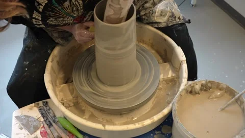 Hands mould pot rotating on potter's wheel and moisten with its sponge Stock Footage 240249195