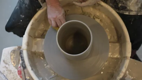 Hands mould pot rotating on potter's wheel and moisten with its sponge Stock Footage 240760656
