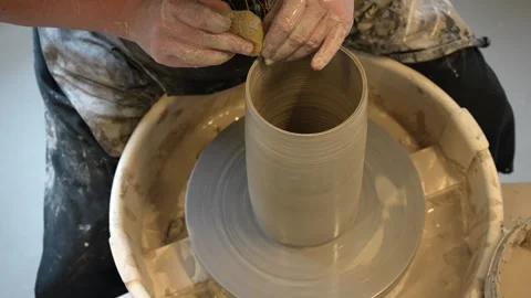 Hands mould pot rotating on potter's wheel and moisten with its sponge Stock Footage 241178205