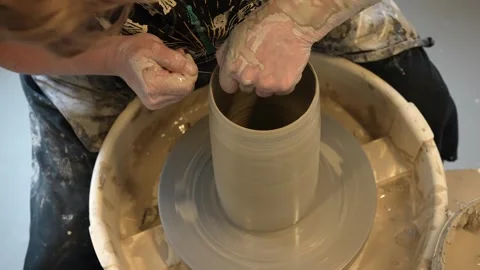 Hands mould pot rotating on potter's wheel and moisten with its sponge Stock Footage 241434996