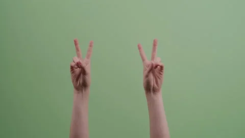 Hands Move up and Gesture Air Quotes in Front of Green Backdrop Stock Footage 208788116