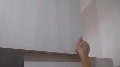 Hands move cabinet away from wall Stock Footage 303385533