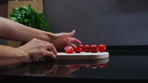 Hands move cutting board with cherry tomatoes Stock Footage 242834665