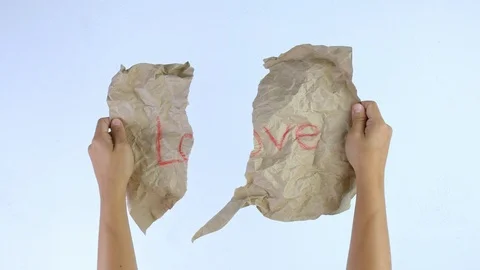 Hands move a half of crumpled kraft paper that written Love word come together. Stock Footage 114558511