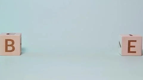 Hands move wooden blocks to form the word "balance" into a new word BE Stock Footage 338187608
