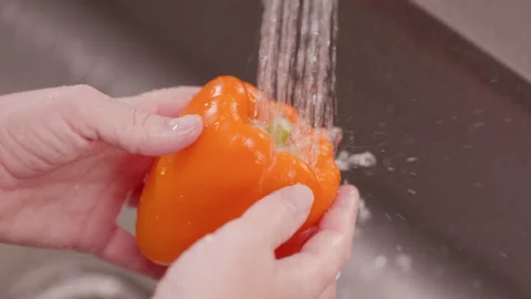 Hands Moves Orange Bell Pepper Under Water to Clean Above Stock Footage 155113160