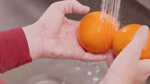 Hands Moves Oranges Under Water to Clean Above Stock Footage 155113162