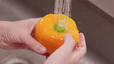 Hands Moves Yellow Bell Pepper Under Water to Clean Above Video stock 155114108