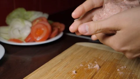 Hands mushing together a roll of raw minced beef to shape it into a patty Video stock 123306029