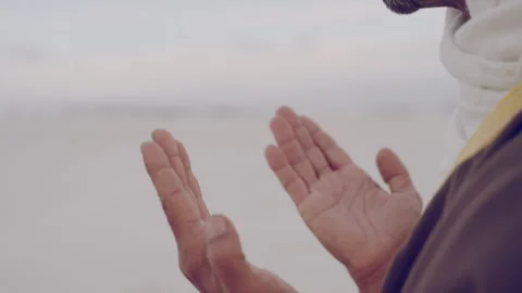 Hands of a Muslim in the desert doing a prayer in the sand on his knees Stock Footage 279723782