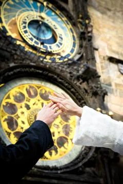 Hands of newly married on clock background on the wall of old town city hall  Stock Photos