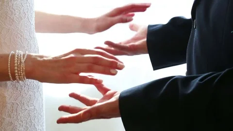 The hands of the newlyweds meet on a light background Stock Footage 77495553
