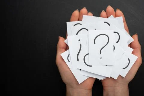 Hands with a note written by a question mark on the background Stock Photos